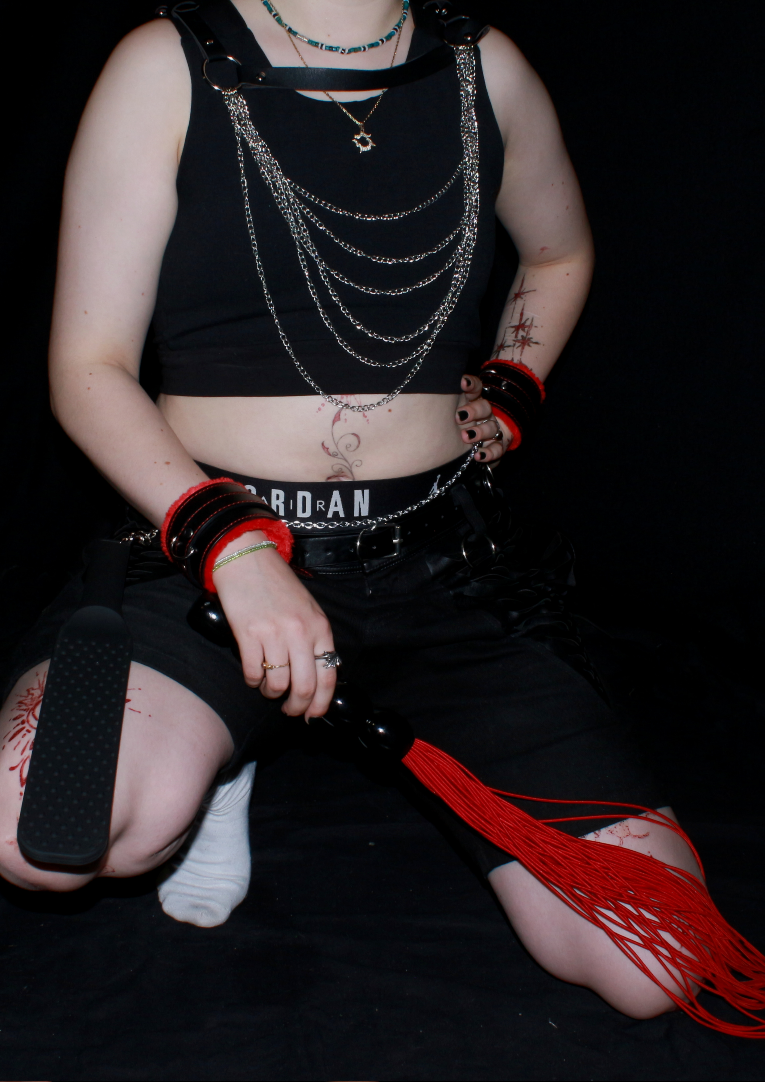 Schwarzes Outfit mit Ketten, Netz und roten Accessoires